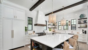 A spacious kitchen with a large island, white cabinetry, and a rustic ceiling beam. - Summer Nights|Easy Beach Access|Private PoolGolf Cart (Santa Rosa Beach)