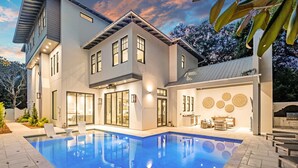 A modern two-story house with a swimming pool, large windows, and a patio area. - Summer Nights|Easy Beach Access|Private PoolGolf Cart (Santa Rosa Beach)