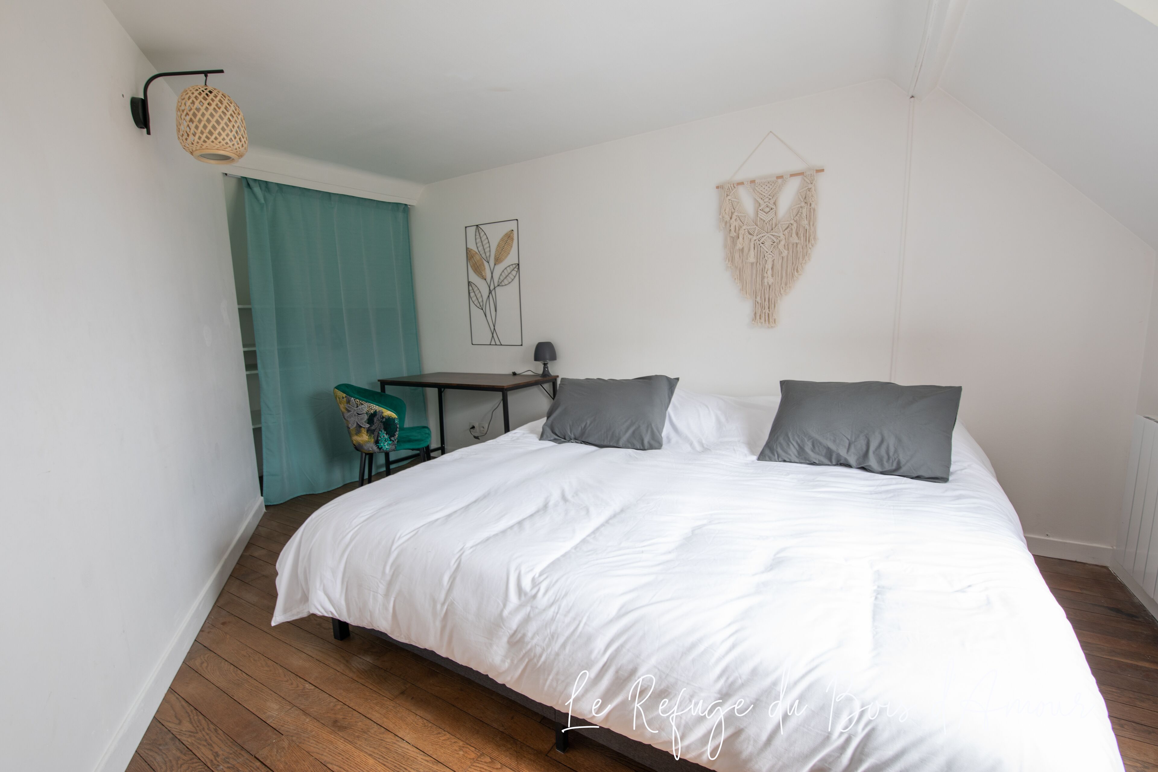 Un dormitorio con una cama grande, un escritorio y una silla.