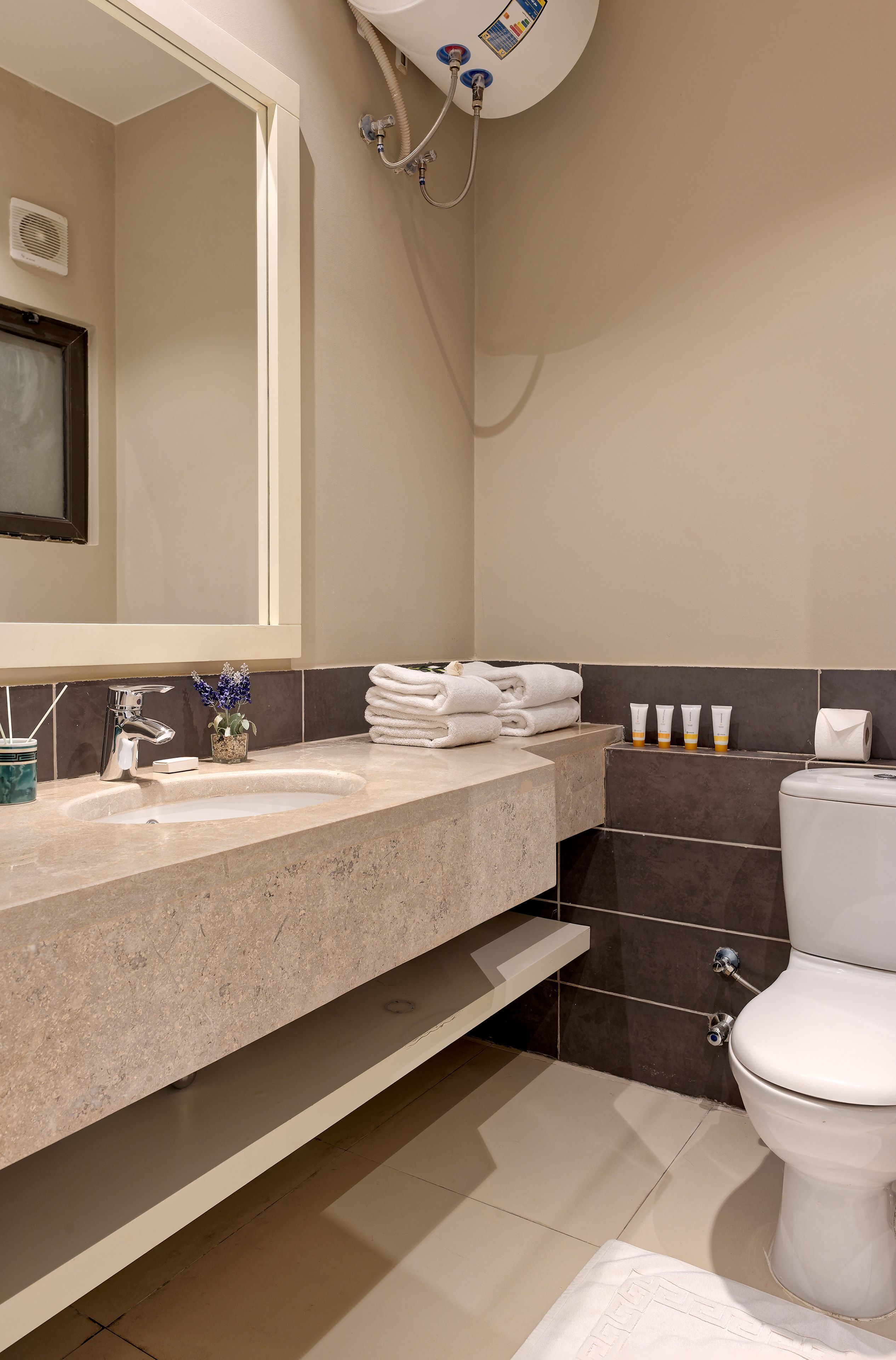 Une salle de bain équipée d’un lavabo, d’un miroir, d’un porte-serviettes, de toilettes et d’une douche.