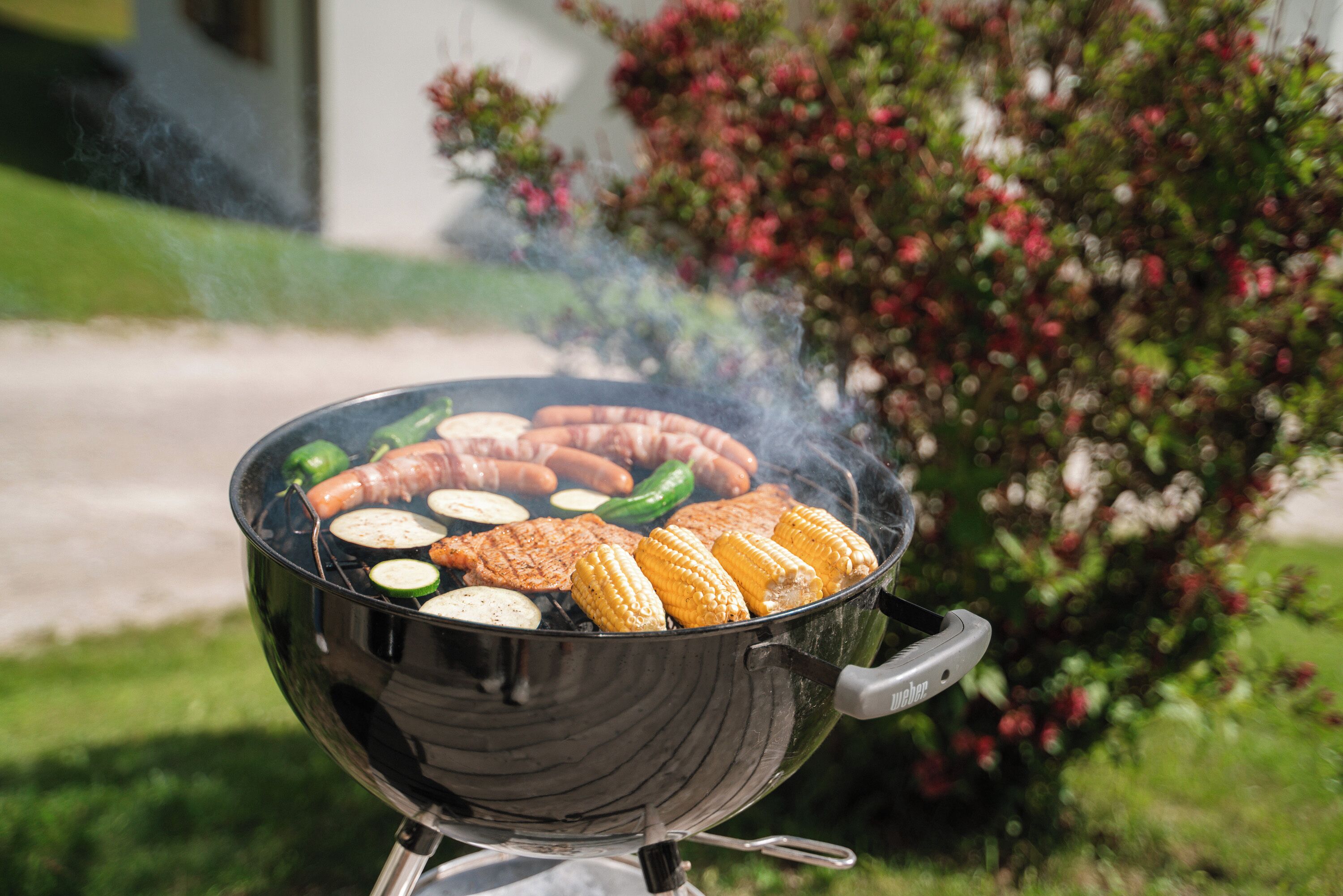 A portable grill with food items being cooked.