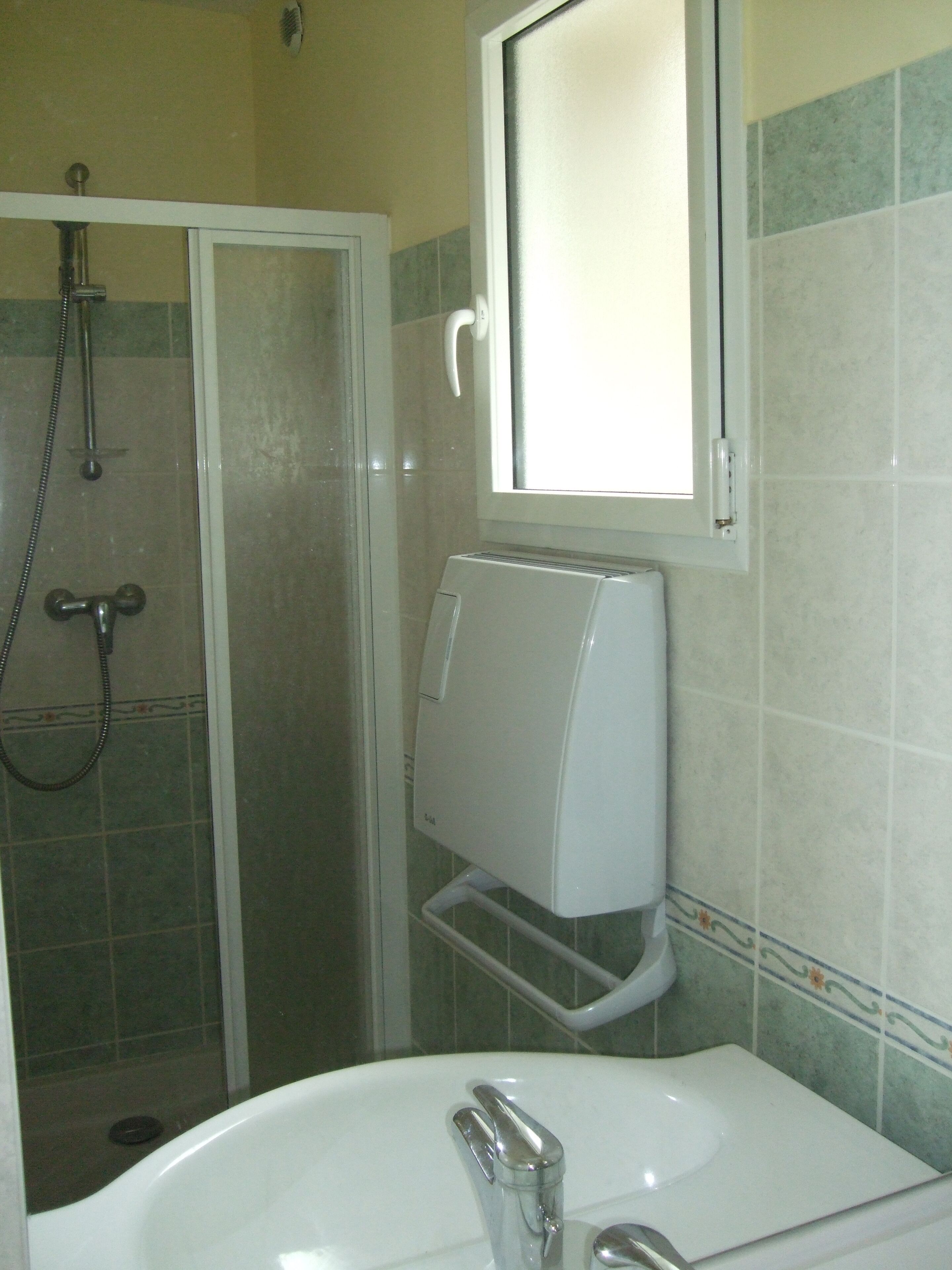 A bathroom with a shower, a toilet, and a sink.
