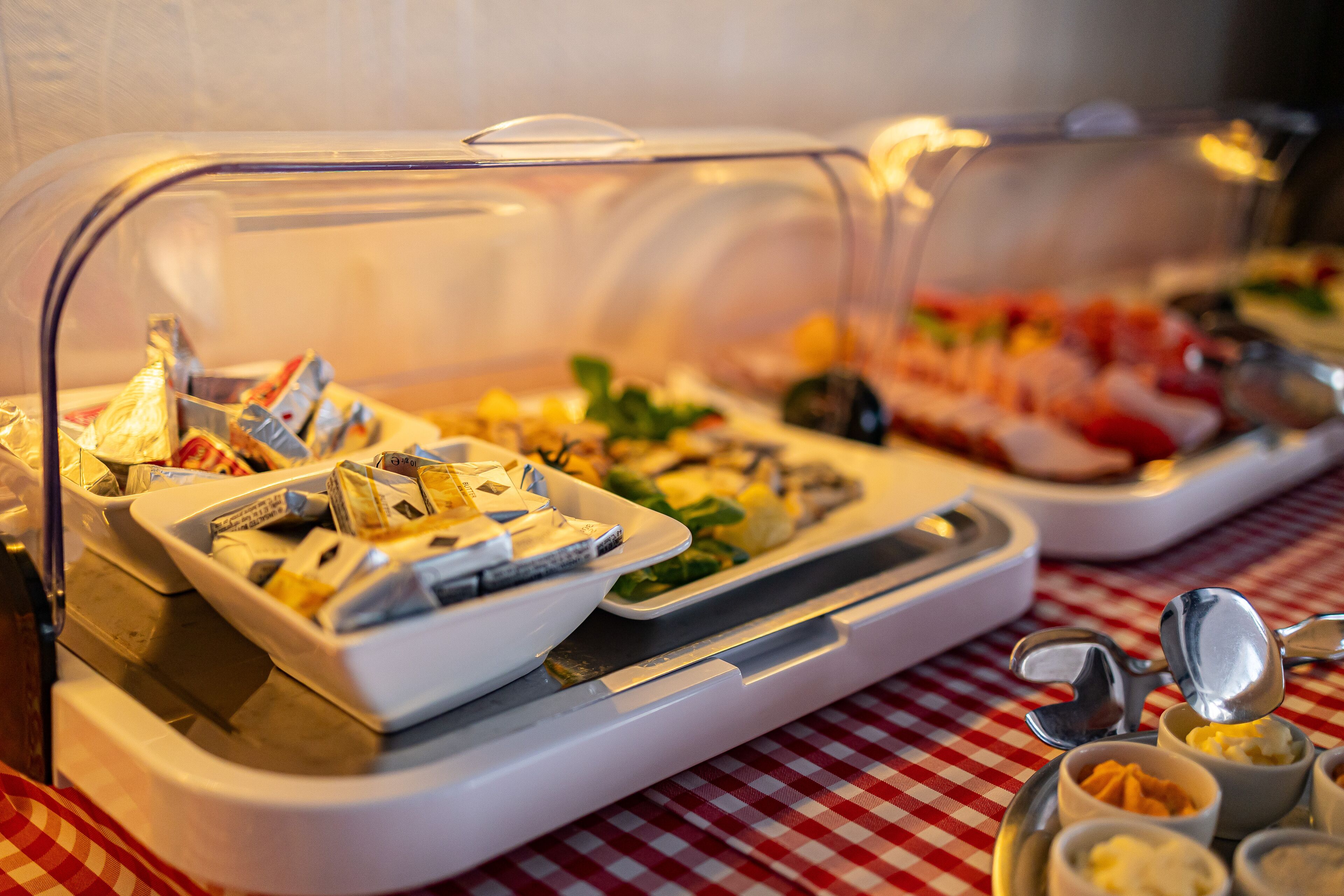 A buffet with various food items, including seafood and salads, served on a table with a checkered tablecloth.