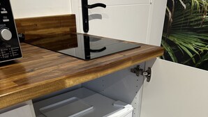 Eine kleine Küche mit Einbauofen und einer Holzauskleidetheke.
