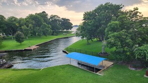 A serene riverside park with a wooden dock, a covered seating area, and lush greenery. - Waterfront with Boat Slip, Sports Bar, SUP'S, Great Location! (Willis)