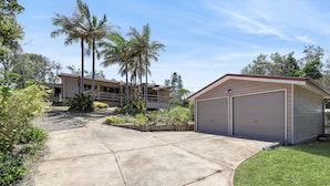 Zona residencial con garaje, palmeras y césped bien cuidado.