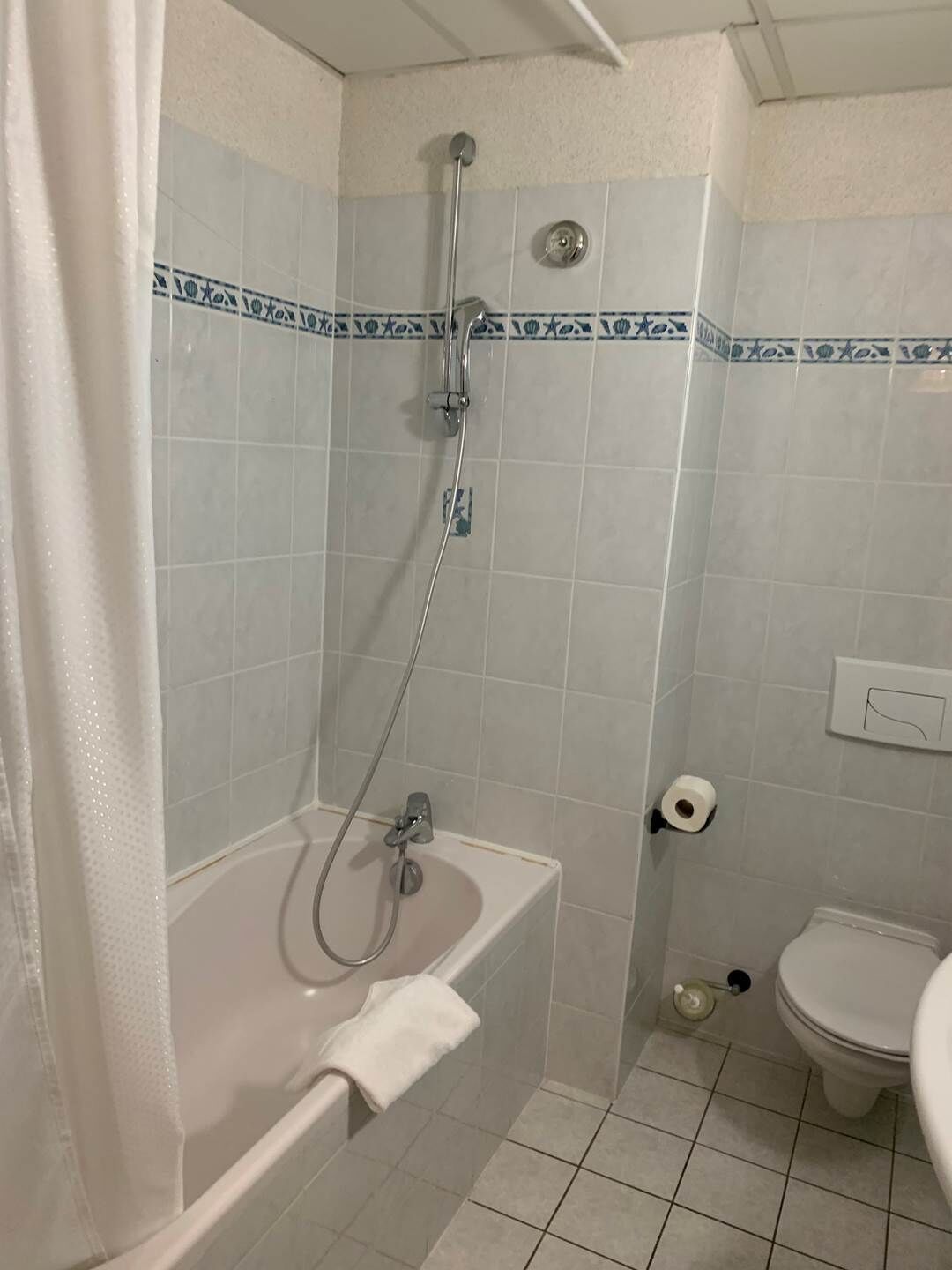 Une salle de bain avec une douche, une baignoire et des toilettes.