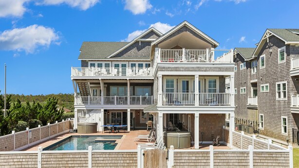 A multi-story residential building with a pool, outdoor seating, and a balcony. - Crew Quarters -- 16BR Oceanfront with Elevator, Pool and More! (Corolla)