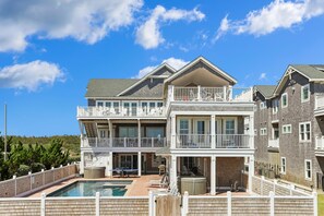 A multi-story residential building with a pool, outdoor seating, and a balcony. - Crew Quarters -- 16BR Oceanfront with Elevator, Pool and More! (Corolla)