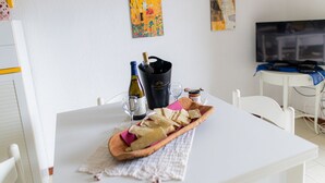 A dining table with a wooden bread basket, wine bottles, glasses, and a honey jar. - VivimiHome–Mare e relax nel cuore di Porto Rotondo (olbia)