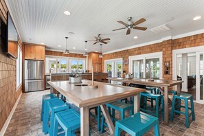A modern kitchen with wooden accents, a central island, and blue bar stools.