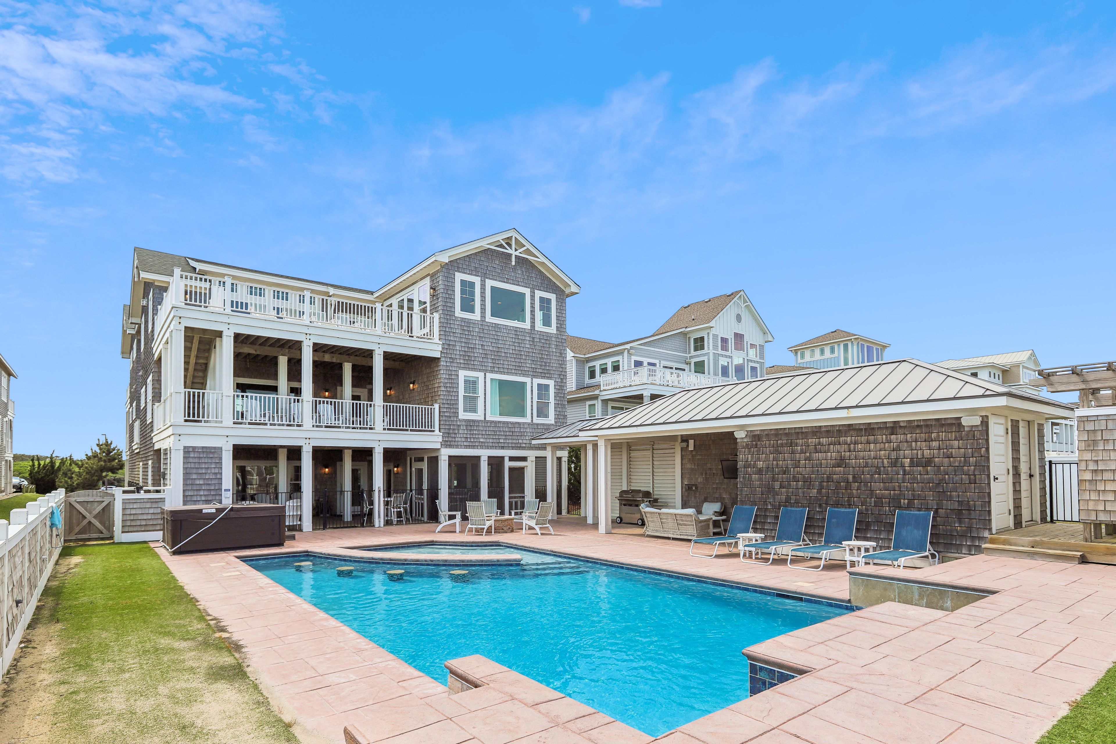 Une maison à deux étages dotée d’une piscine, d’un espace extérieur aménagé et d’un patio couvert.