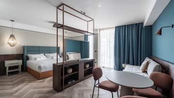 Une chambre d’hôtel moderne équipée d’un lit, d’un bureau, d’une chaise, d’une table et d’une grande fenêtre avec des rideaux.
