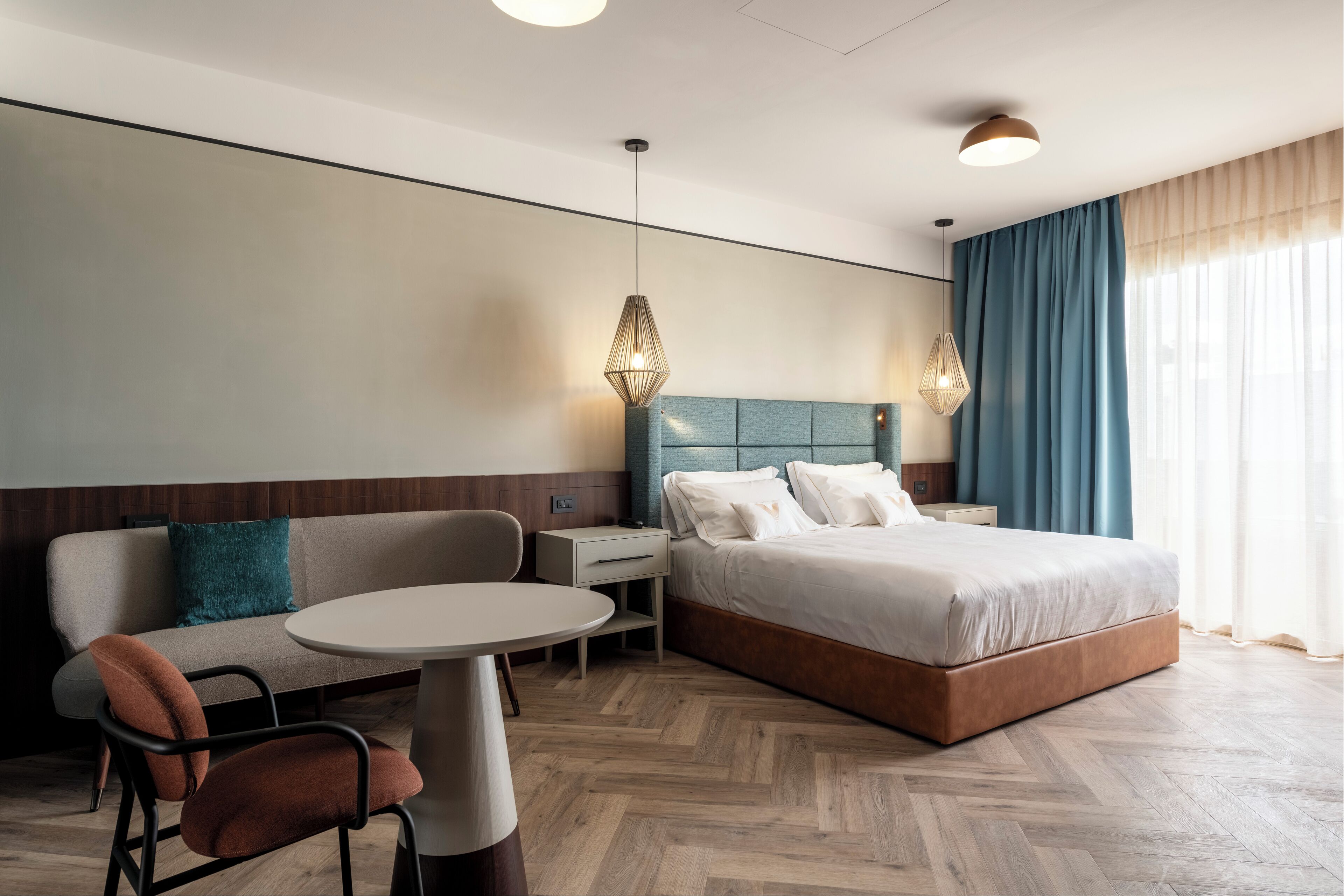 Une chambre d’hôtel moderne, équipée d’un lit, d’un canapé, d’une table et d’une chaise.