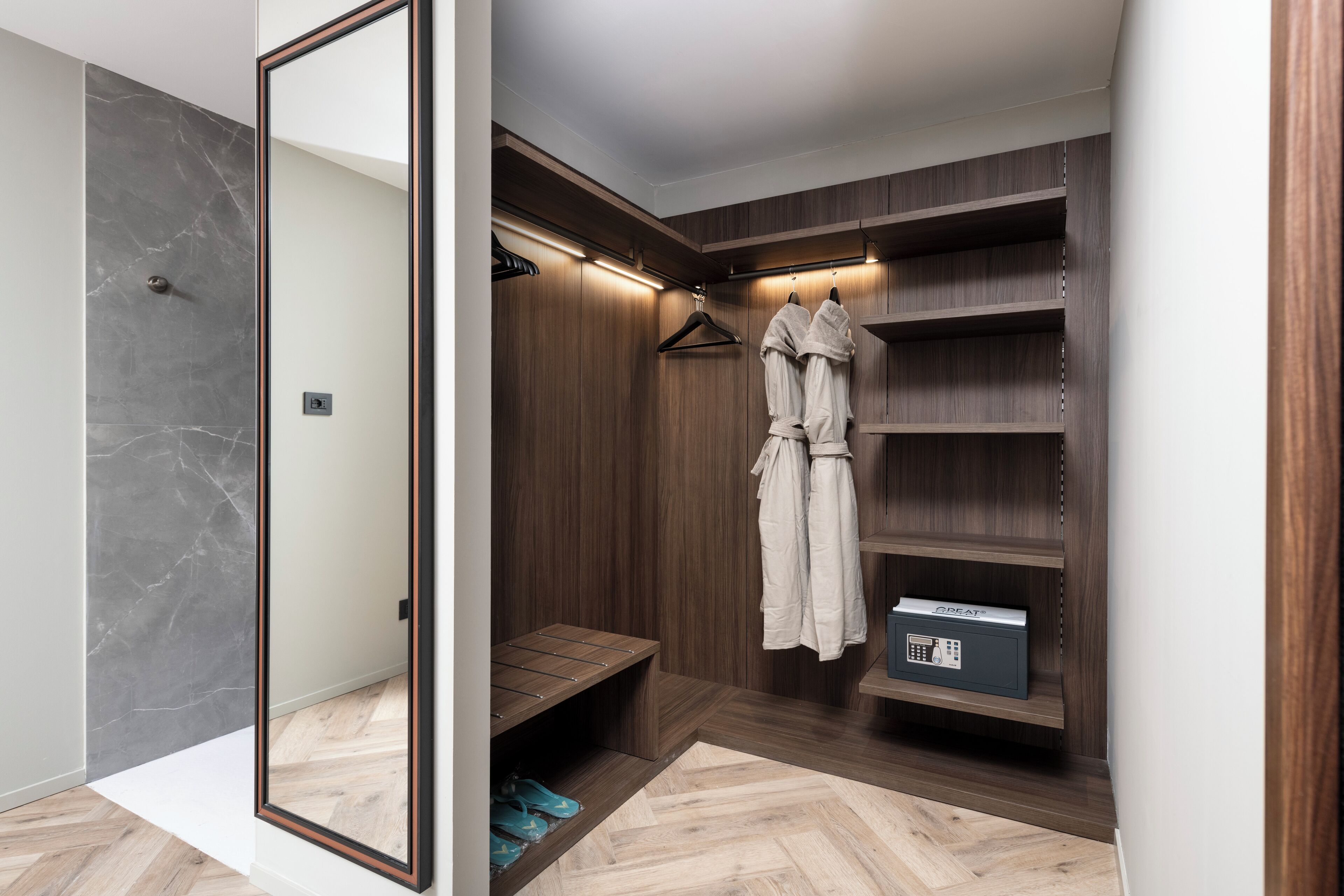 Un vestidor con estantes de madera, una barra para colgar ropa y un zapatero.