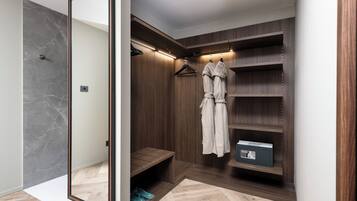 Un vestidor con estantes de madera, una barra para colgar ropa y un zapatero.
