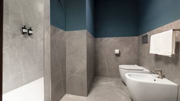 Une salle de bain moderne avec un lavabo aux lignes courbes, un porte-serviettes et un espace douche.
