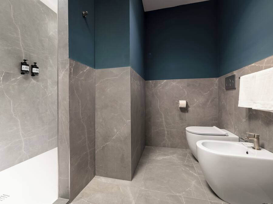 Une salle de bain moderne avec un lavabo aux lignes courbes, un porte-serviettes et un espace douche.