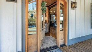 A wooden entrance with glass doors, a welcome mat, and a hanging wreath. - Wine Down Ridge- Blue Ridge GA (Blue Ridge)