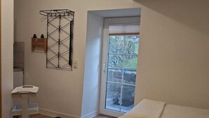 Ein Schlafzimmer mit Bett, einem kleinen Tisch, einem Wäscheständer und einem Fenster mit Blick.