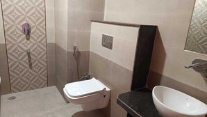 A bathroom with a toilet, a sink, and a shower. - The Kapji Palace (Jaipur)