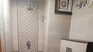 A bathroom with a shower, toilet, and sink. - The Kapji Palace (Jaipur)