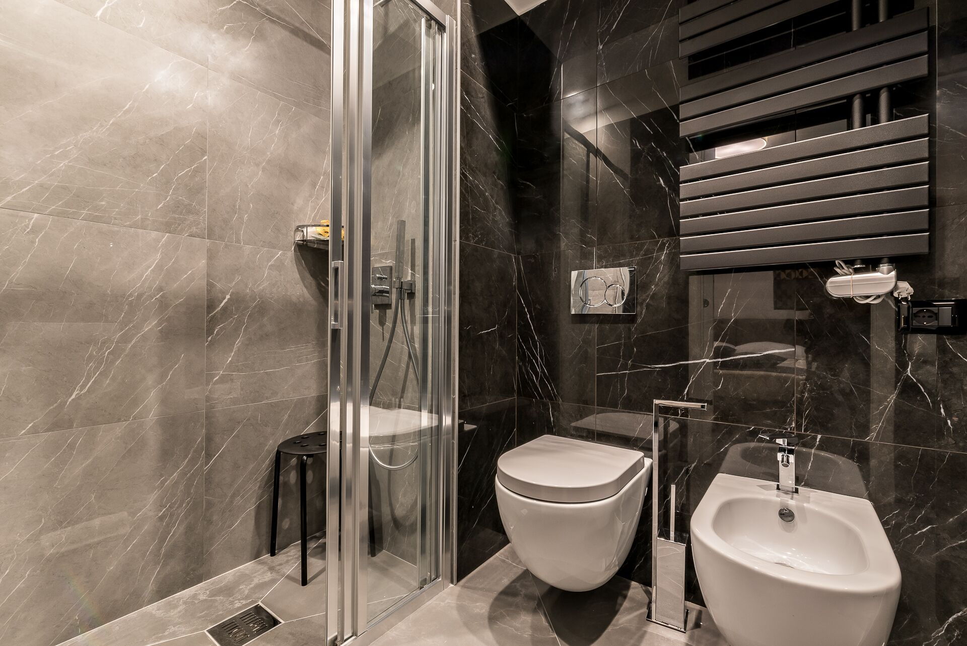 Une salle de bain moderne dotée d’une douche à parois de verre, de toilettes et d’un bidet.
