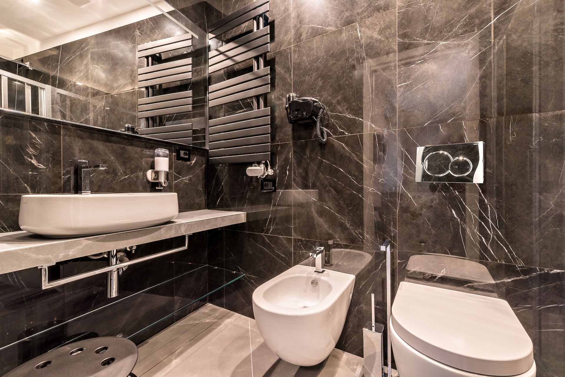A modern bathroom with a large sink, bidet, and toilet.