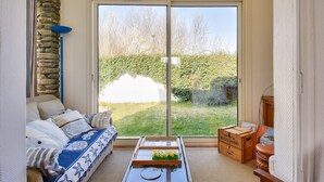 Un salon chaleureux avec un canapé, une table basse et un mur en pierre.