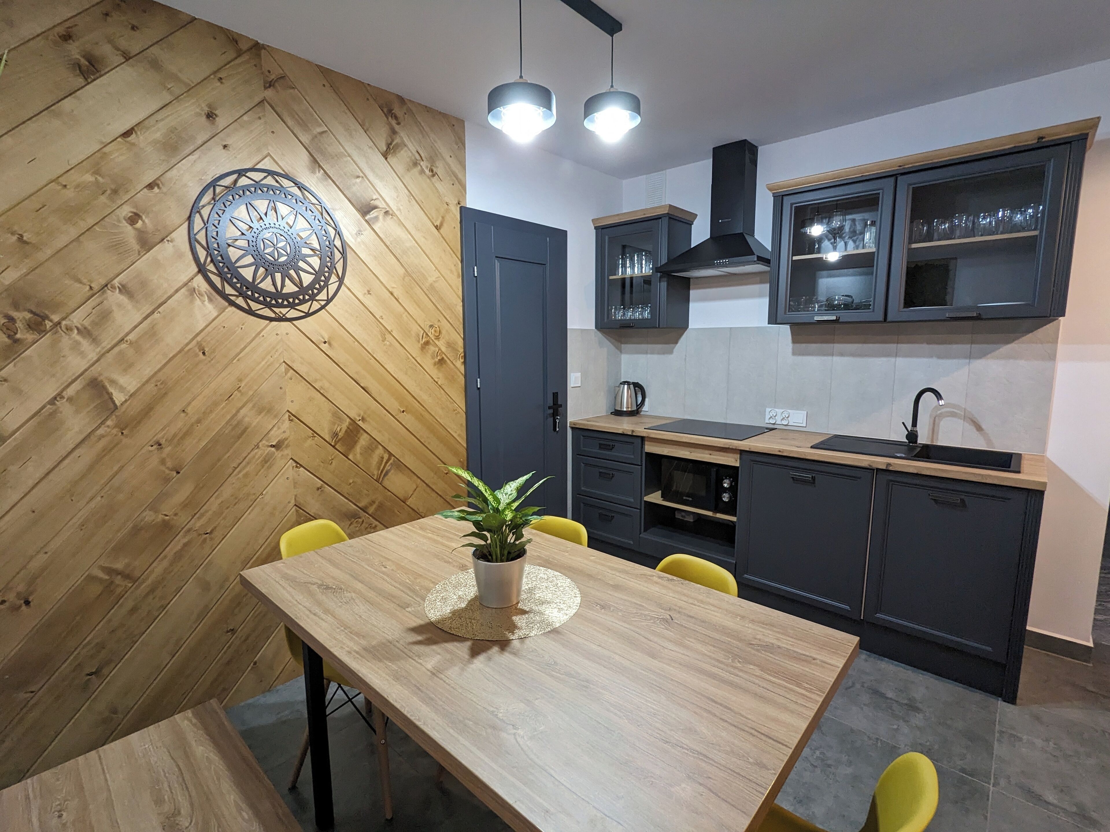 Une cuisine moderne avec des murs en bois, une table à manger avec des chaises et des placards intégrés.