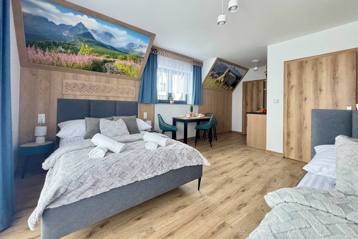 A bedroom with a bed, a desk, and a dining area.