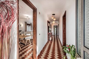 Un pasillo con suelo estampado, puertas de madera e iluminación colgante.