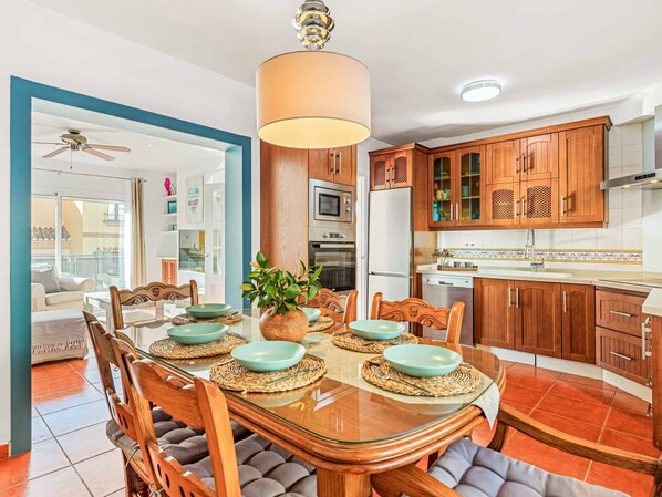 Enjoy meals in this well-appointed dining area with a glass-top table for four, adjacent to a balcony with a view.