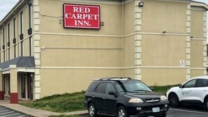 Un bâtiment de la chaîne Red Carpet Inn avec un parking.