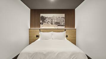 A neatly made bed with a headboard that has a vertical wooden panel design.