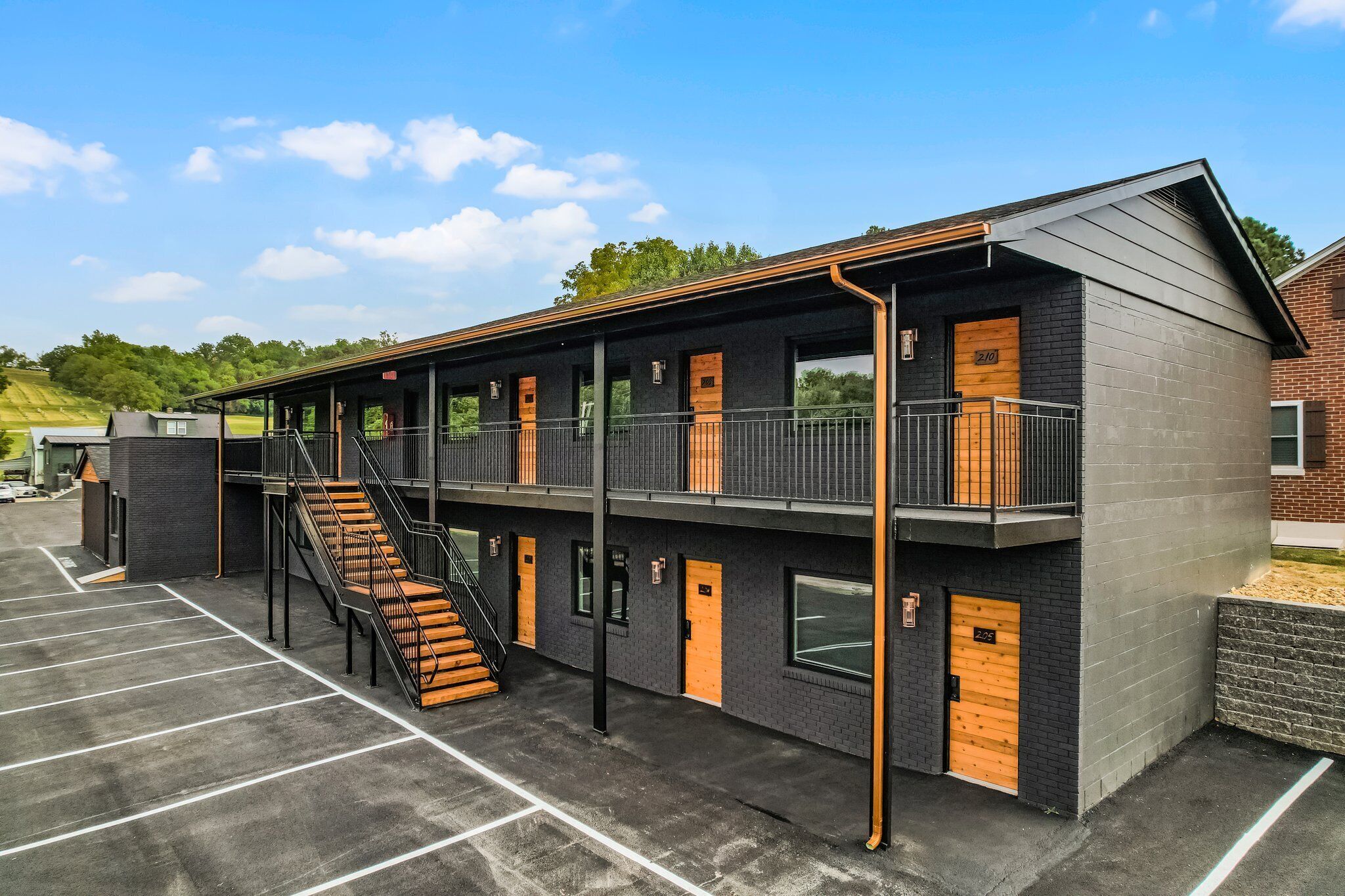 A modern building with a two-story structure, multiple doors, and a staircase leading to the upper level.