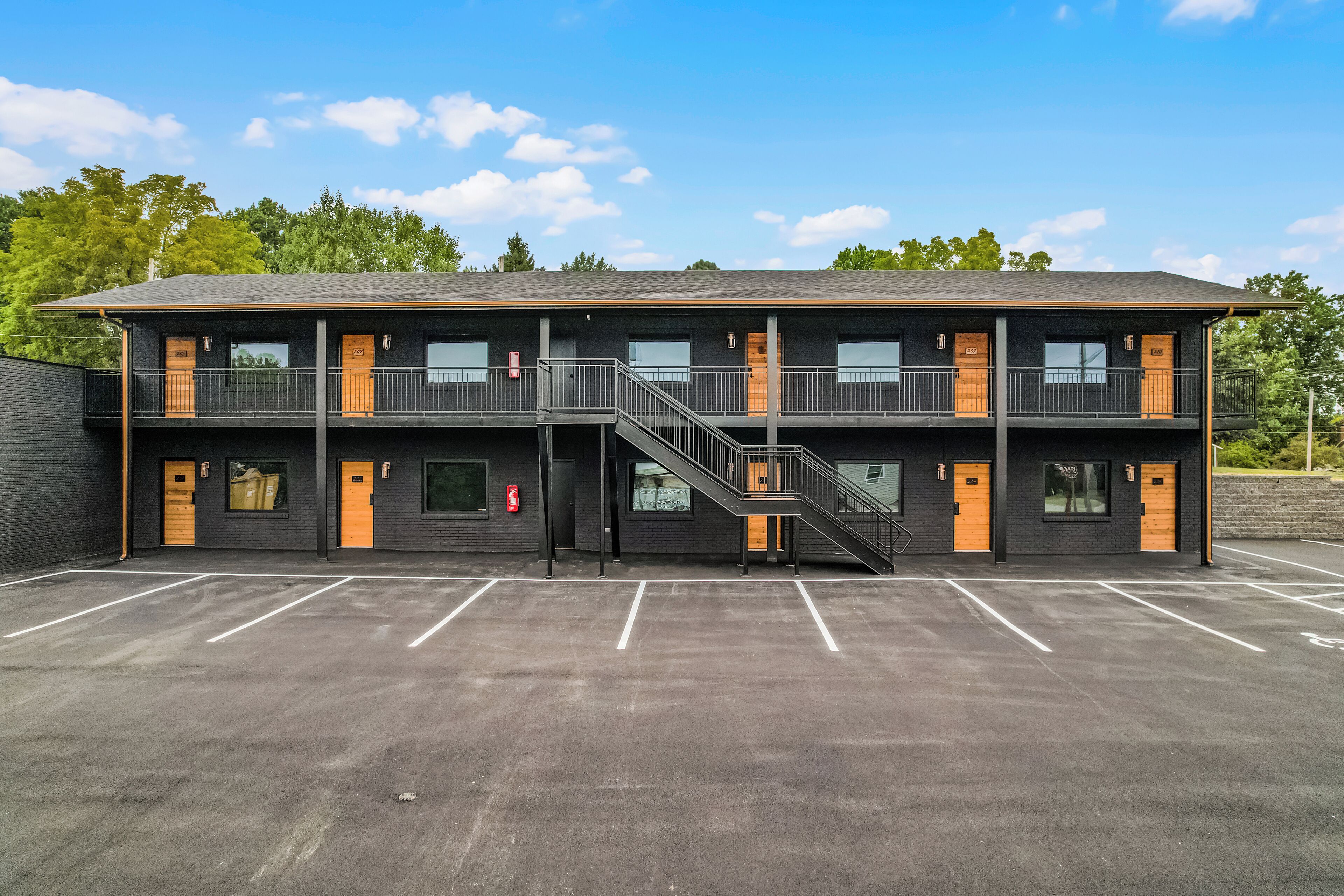 A two-story building with a parking lot in front.