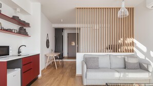 Ein zeitgemäßer Wohnraum mit Küche, Essbereich und einer Couch.