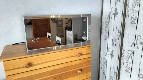 Un aparador de madera con un espejo que refleja el interior de una habitación.