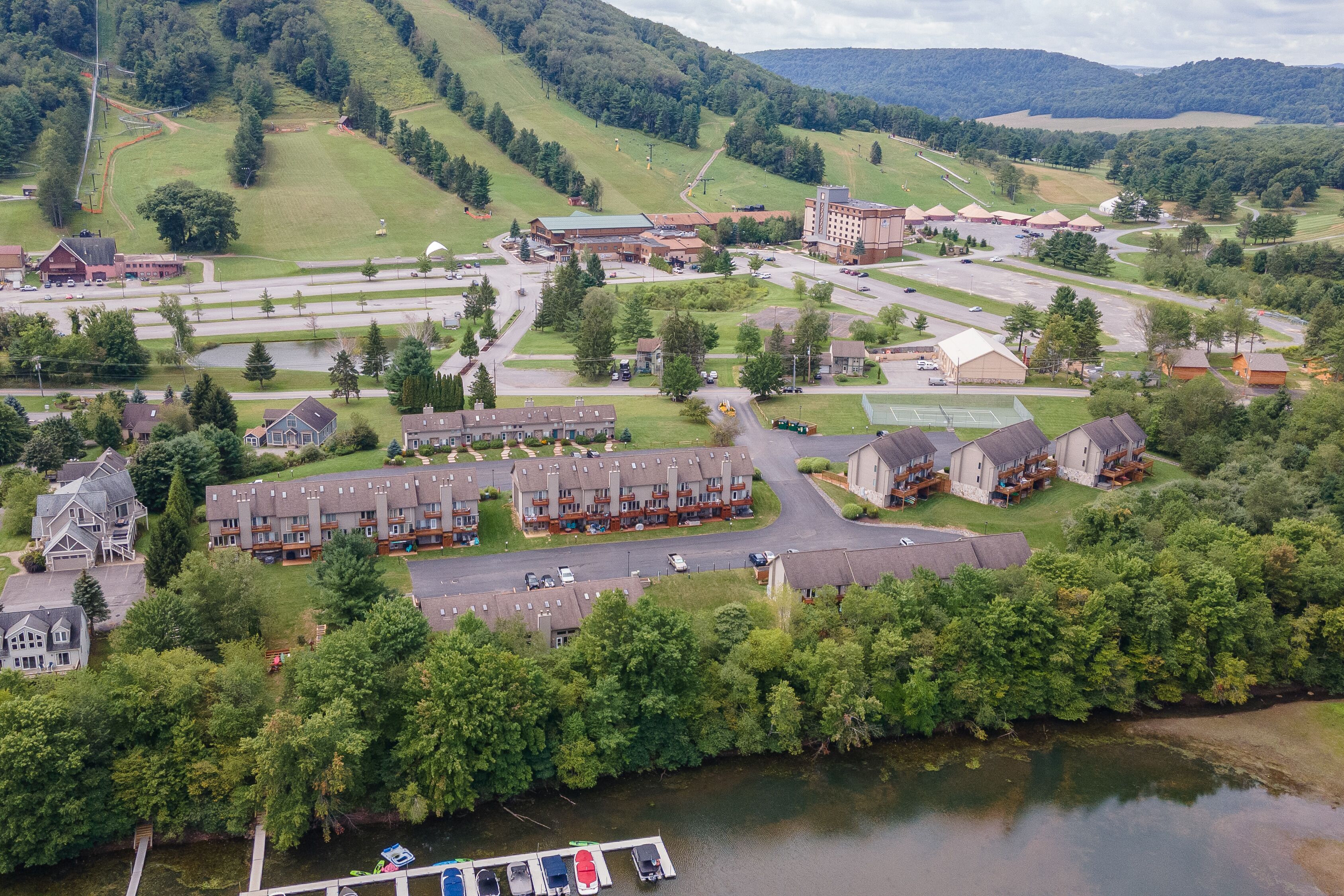 Vista aérea de una zona residencial con casas, un estacionamiento y un río.