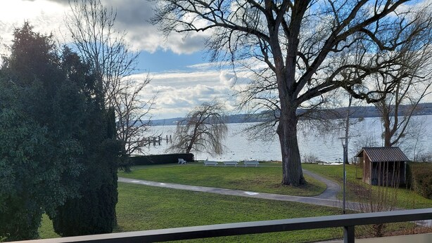 A lakeside park with a pathway, benches, and a small wooden structure. - 2-room vacation apartment directly on Lake Constance with bathing area (Überlingen)
