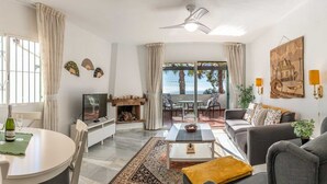 Ein geräumiger Wohnbereich mit Esstisch, Sofa und Kamin.