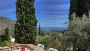 A terrace with a table and chairs, overlooking a scenic landscape with trees and a view of the sea. - The Old Mill: Pool, Sleeps 8, WiFi, 4 bed, views (Frigiliana)