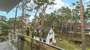 A residential area with a small white house surrounded by tall trees.