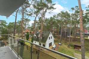 Un barrio residencial con una pequeña casa blanca rodeada de árboles altos.