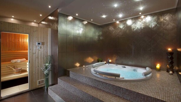A modern spa with a hot tub, wooden sauna, and tiled steps leading to the tub. - Charming Villa Diora with a swimming pool and wellness area (Karojba)