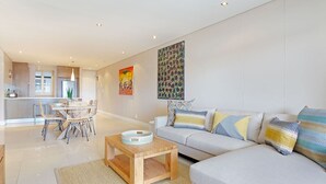 Una sala de estar moderna con sofá, mesa de centro y comedor.