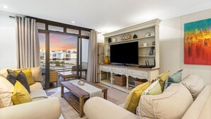 Un salon moderne comprenant un ensemble de canapés, une table basse, un téléviseur à écran plat et une cheminée.