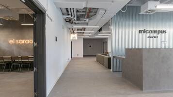 Un espacio de oficina moderno con una zona de recepción que indica 'micampus madrid'.