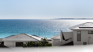 A coastal view with a white building and a clear blue sky.